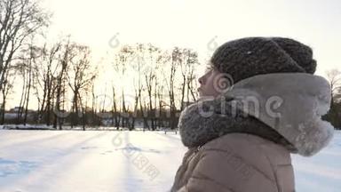 少女在冬天的公园里把白雪抛起来微笑。 圣诞<strong>节</strong>。 在寒冷的日子里举行雪的<strong>运动会</strong>